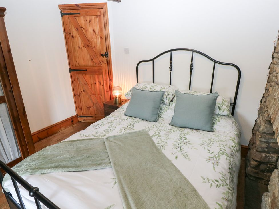 A bedroom with a bed and wooden door at Melyn in Aberdare
