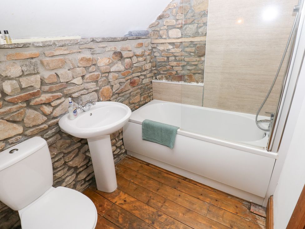 A bathroom with a bath tub, sink, and toilet at Melyn in Aberdare