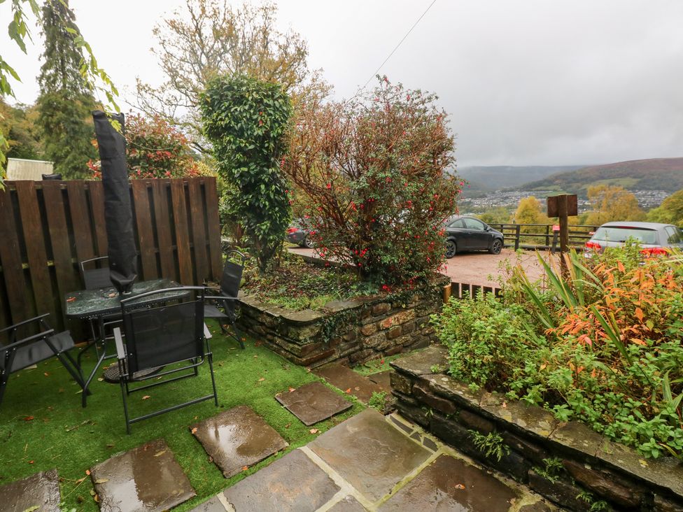 A garden with a table and chairs at Melyn Aberdare