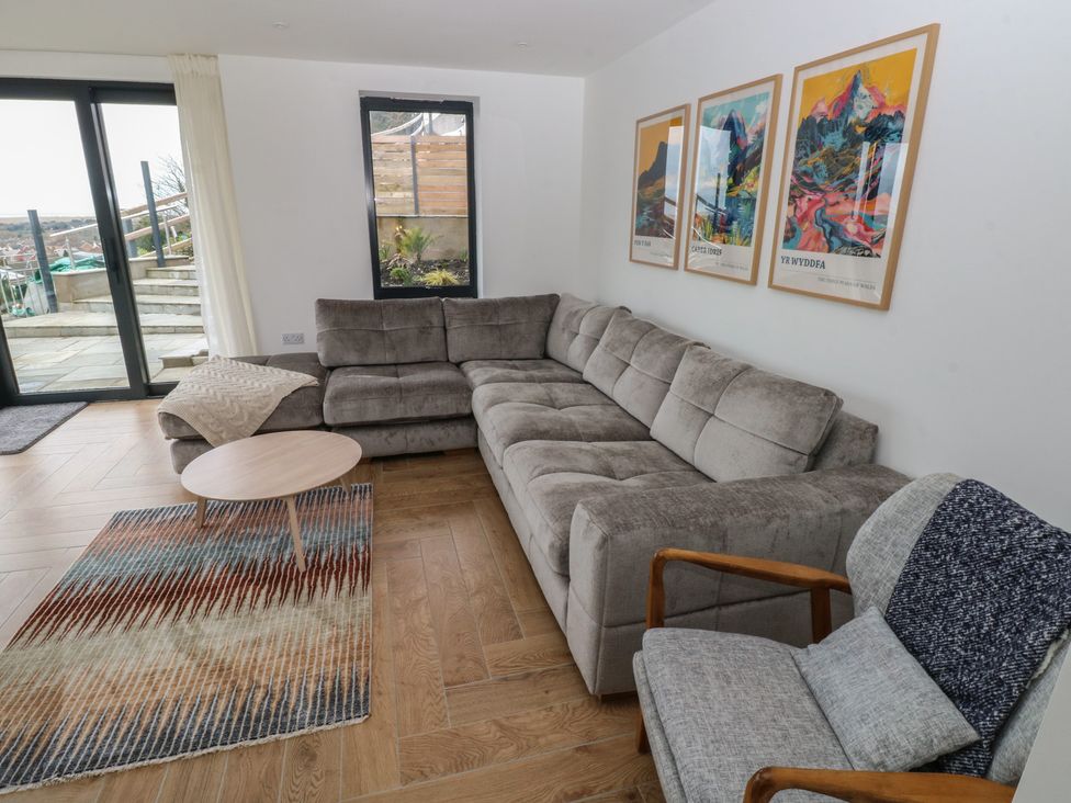A living room with a sectional sofa and coffee table at Awelfryn 