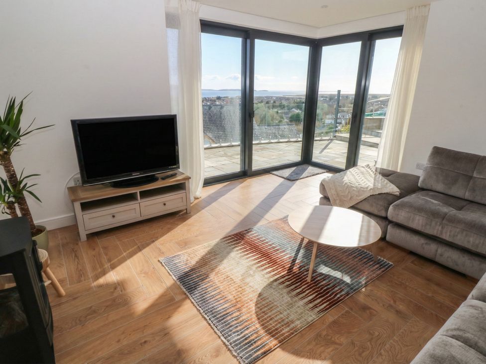 A living room with a TV and sofa at Awelfryn 