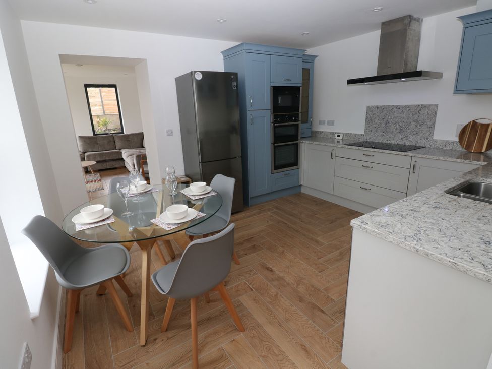 A kitchen with a dining table and chairs at Awelfryn