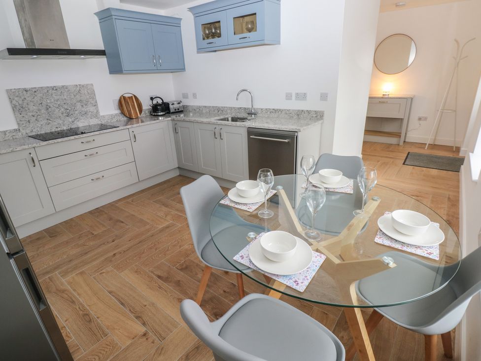 A kitchen with a round table and chairs at Awelfryn