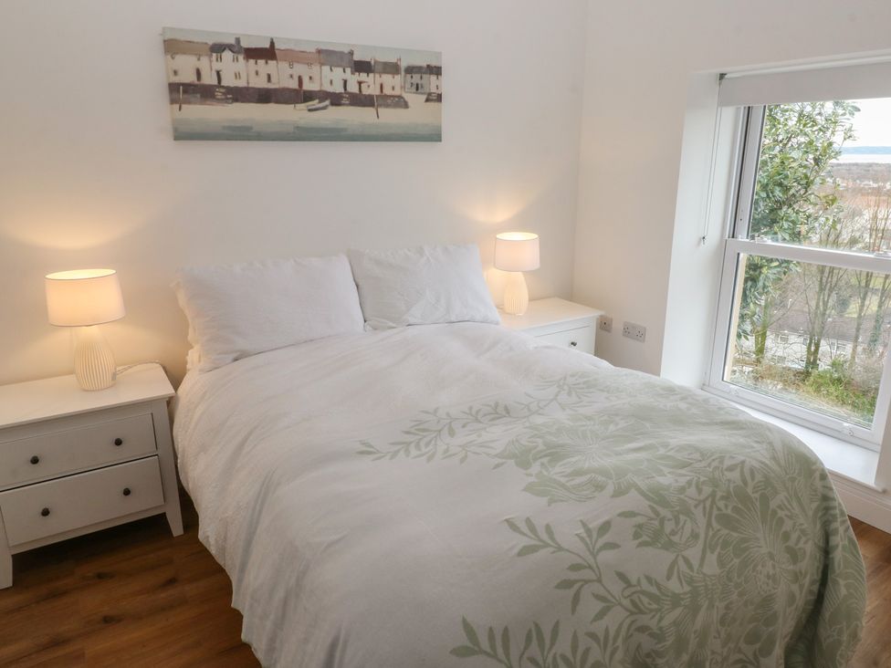 A bedroom with a bed and two lamps at Awelfryn 