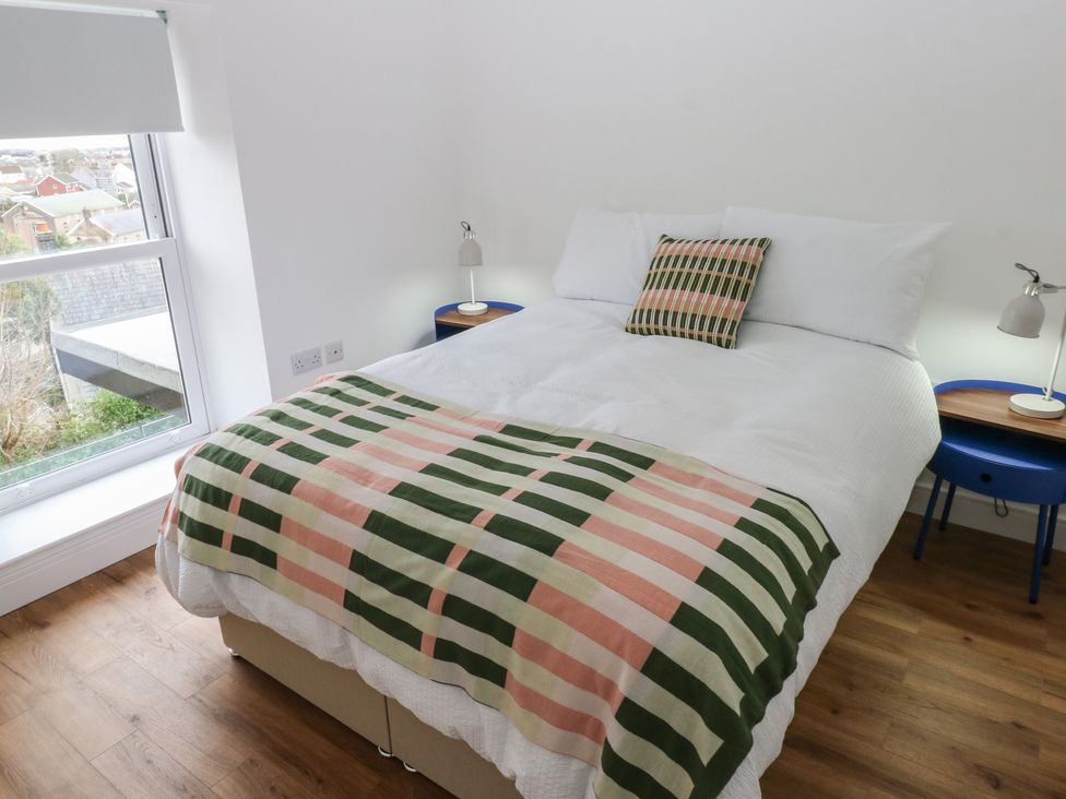 A bedroom with a bed and side tables at Awelfryn