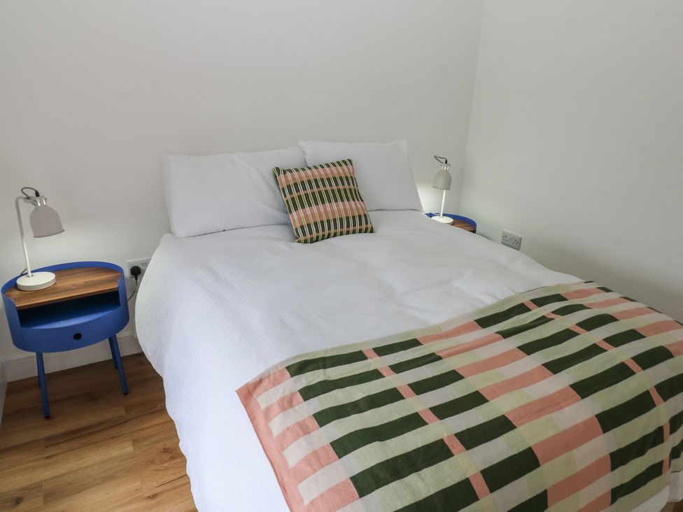 A bedroom with a bed and bedside tables at Awelfryn