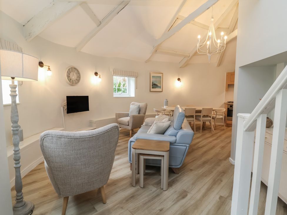 A living room with a sofa and dining table at Round Barn in Ilfracombe