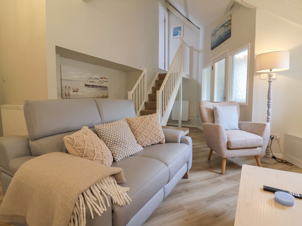 A living room with a sofa and staircase at Round Barn in Ilfracombe