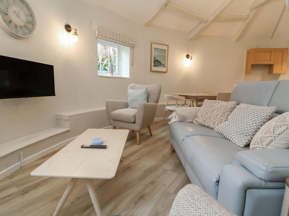 A living room with a television and seating area at Round Barn in Ilfracombe