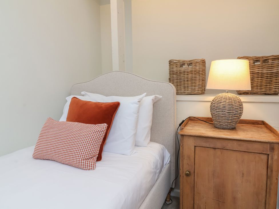 A bedroom with a bed and nightstand at Round Barn in Ilfracombe