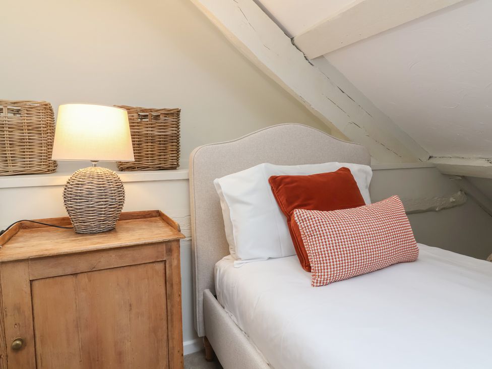 A bedroom with a bed and bedside lamp at Round Barn in Ilfracombe