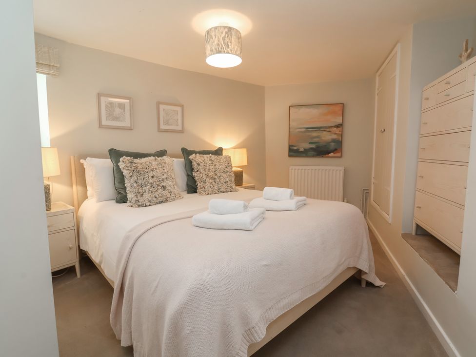 A bedroom with a double bed and lamps at Round Barn Ilfracombe