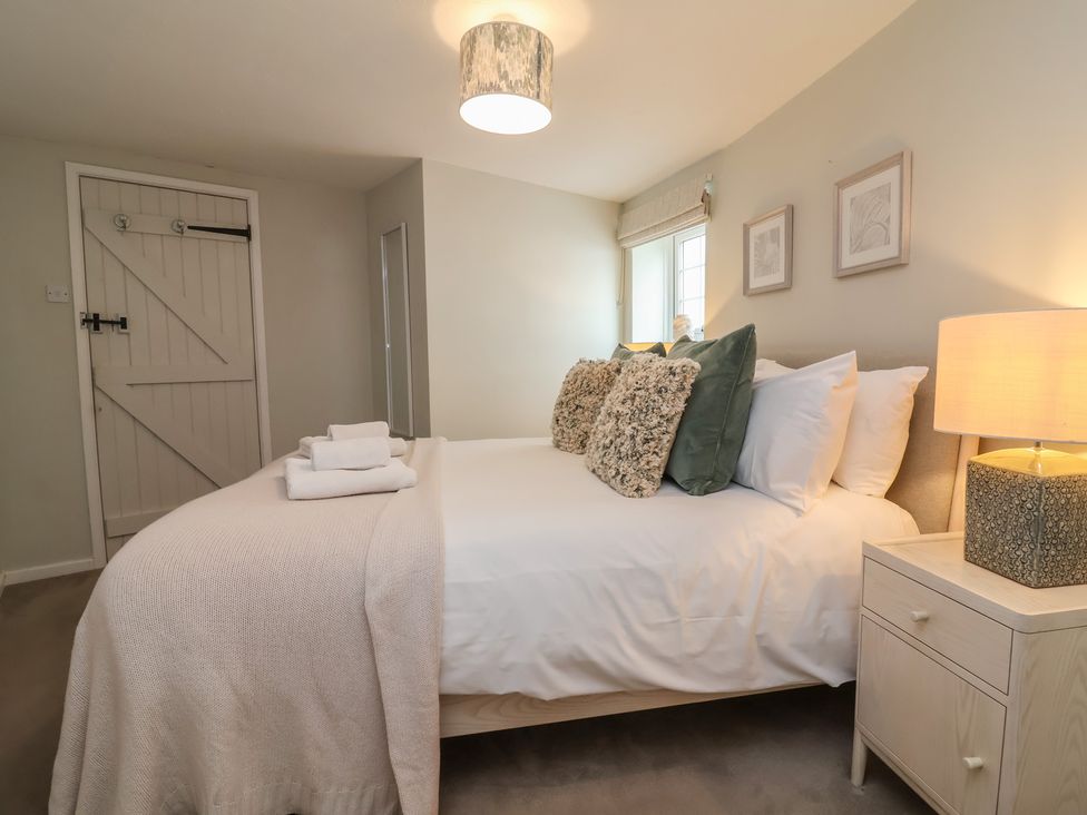 A bedroom with a bed and bedside table at Round Barn in Ilfracombe