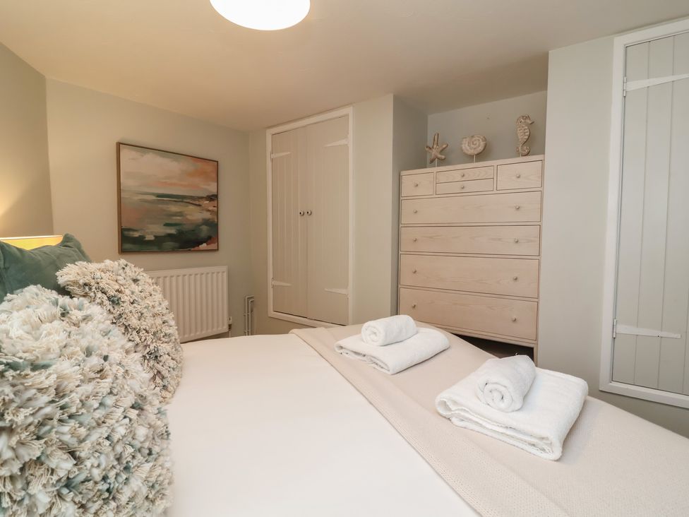 A bedroom with a bed and dresser at Round Barn in Ilfracombe