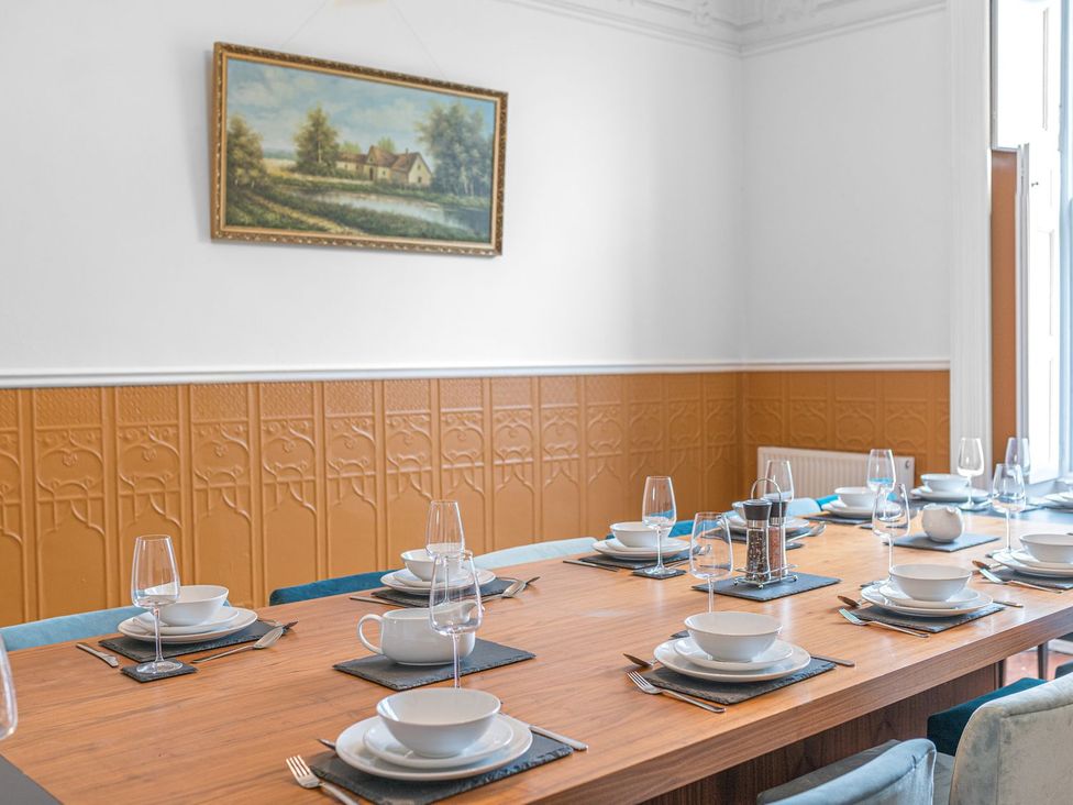 A dining room with a table set for dinner at 8 Corkickle in Whitehaven