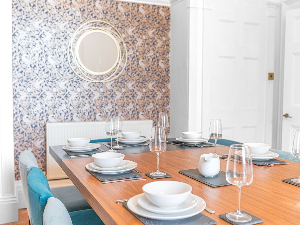 A dining room with a table set for dinner at 8 Corkickle, Whitehaven