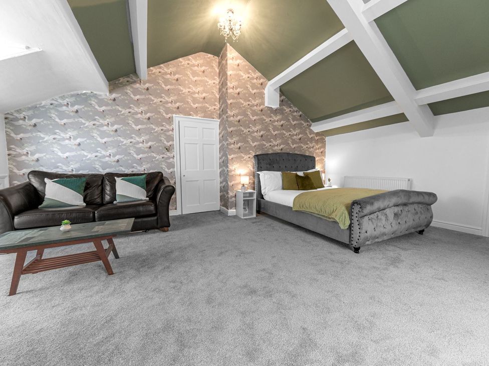 A bedroom with a sofa and a bed at 8 Corkickle Whitehaven