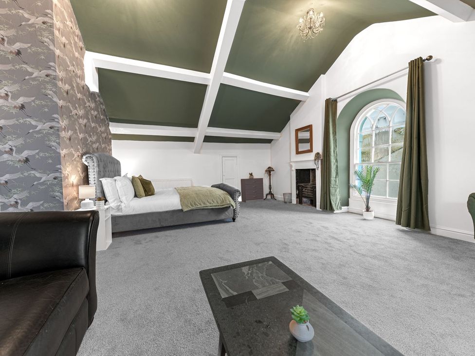 A bedroom with a bed, fireplace and window at 8 Corkickle Whitehaven
