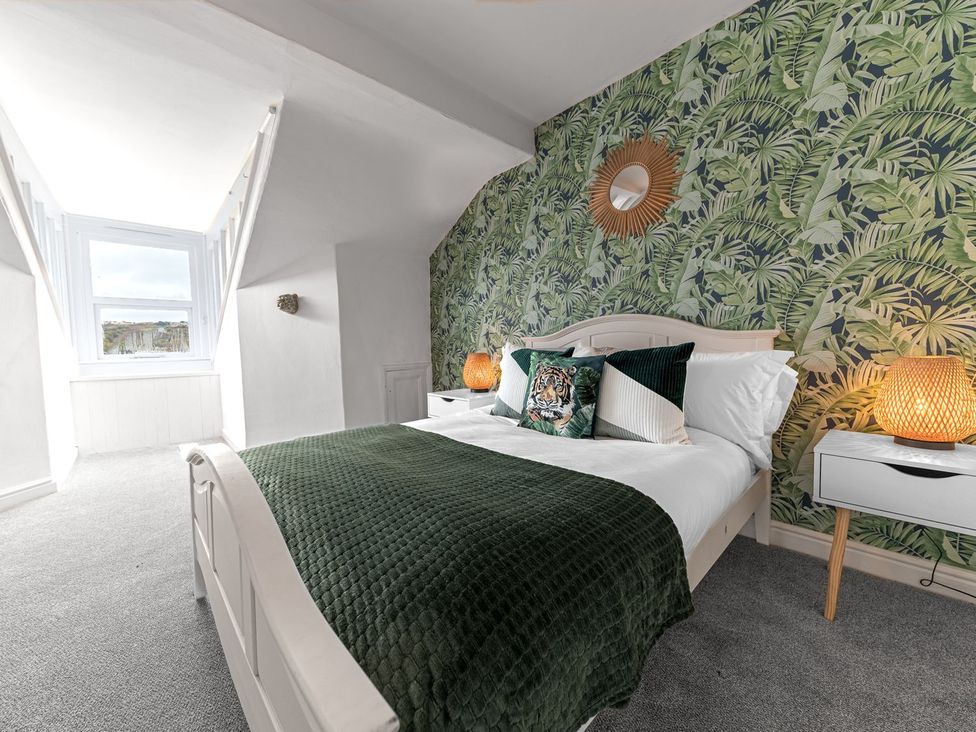 A bedroom with a bed and decorative elements at 8 Corkickle Whitehaven