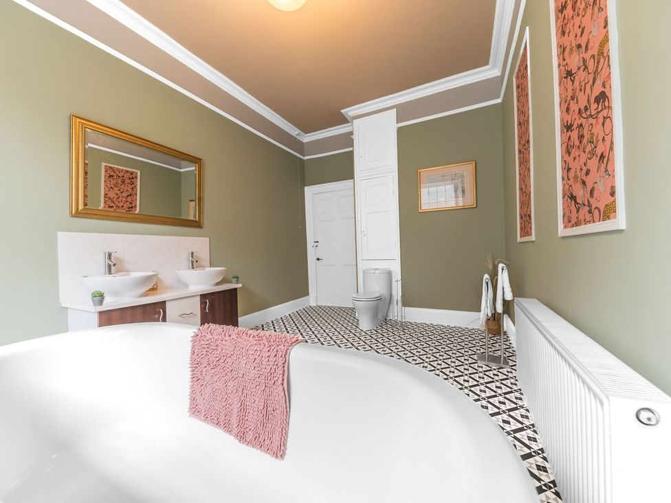 A bathroom with a bathtub and two sinks at 8 Corkickle in Whitehaven