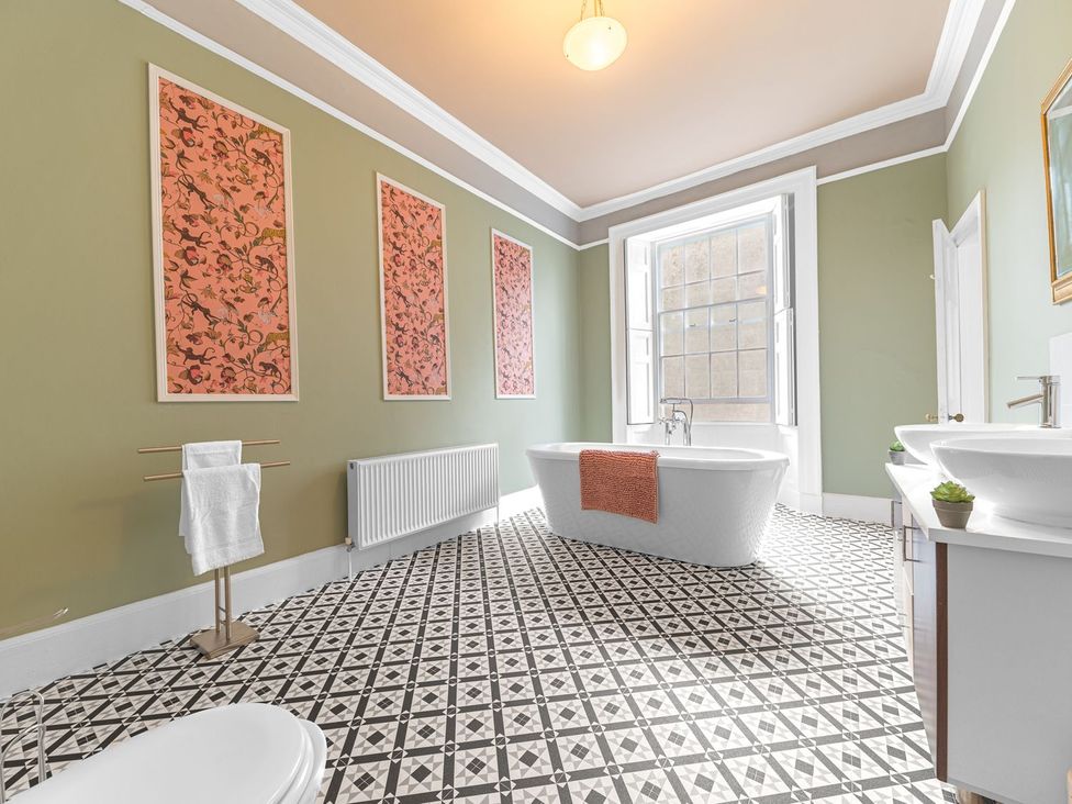 A bathroom with a bathtub, sink, and towel rack at 8 Corkickle Whitehaven