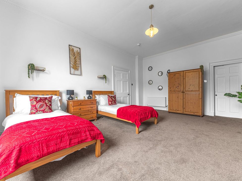 A bedroom with two beds and furniture at 8 Corkickle in Whitehaven