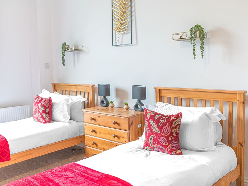 A bedroom with twin beds and a wooden dresser at 8 Corkickle, Whitehaven