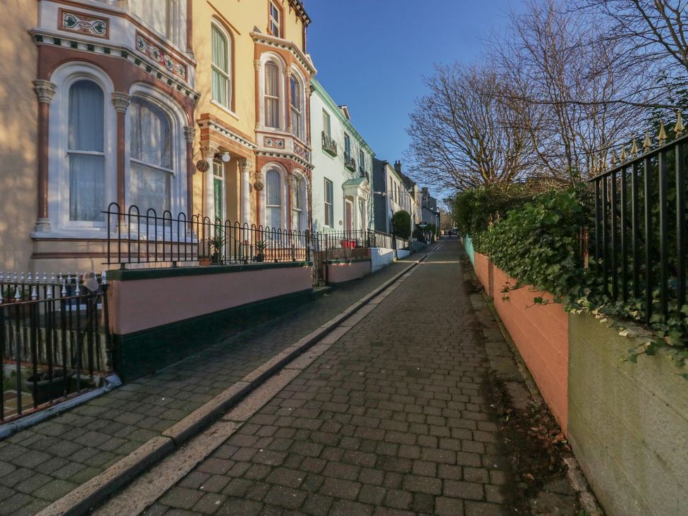 A street with colorful buildings and trees at 8 Corkickle, Whitehaven