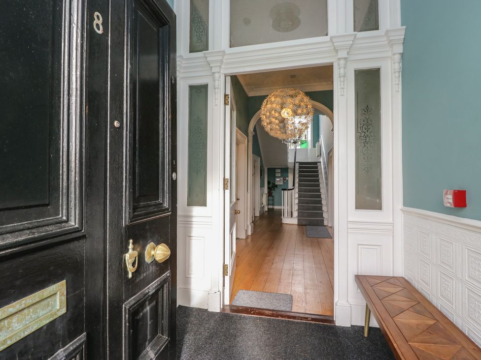 A hallway with stairs and a chandelier at 8 Corkickle Whitehaven