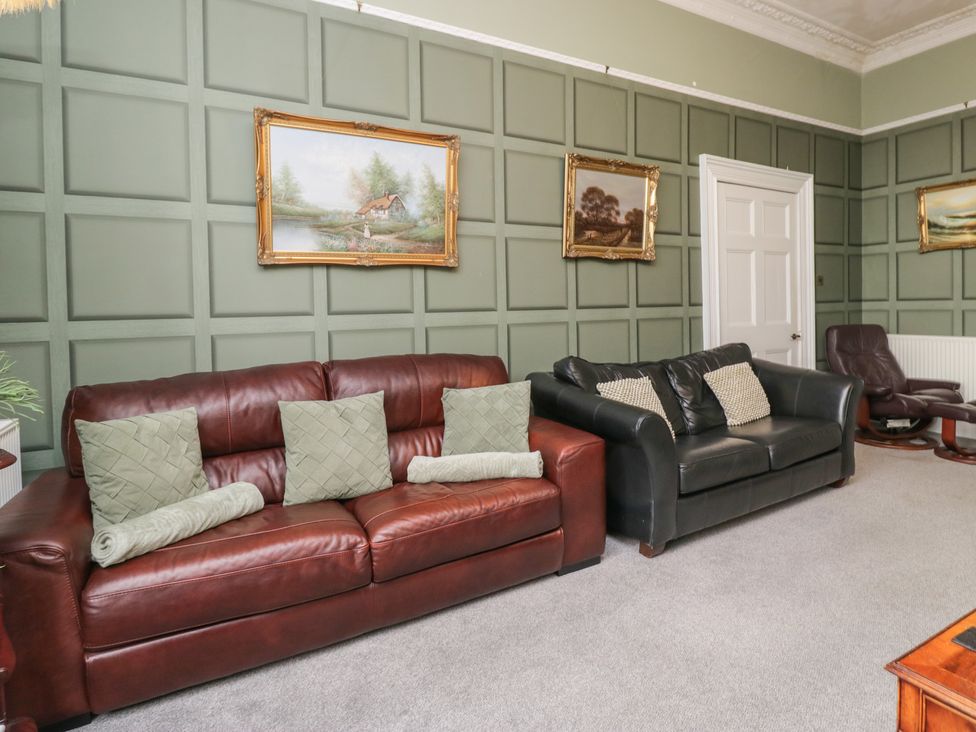 A living room with sofas and wall art at 8 Corkickle Whitehaven