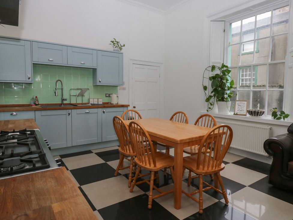 A kitchen with a wooden table and chairs at 8 Corkickle Whitehaven