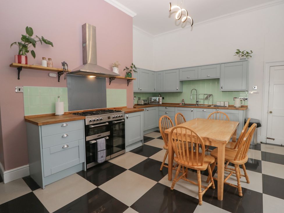 A kitchen with cooking appliances and dining table at 8 Corkickle in Whitehaven