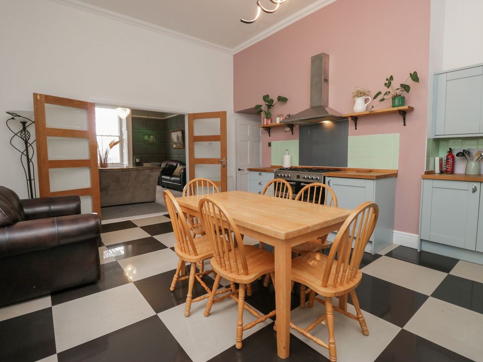 A kitchen with a wooden table and chairs at 8 Corkickle Whitehaven