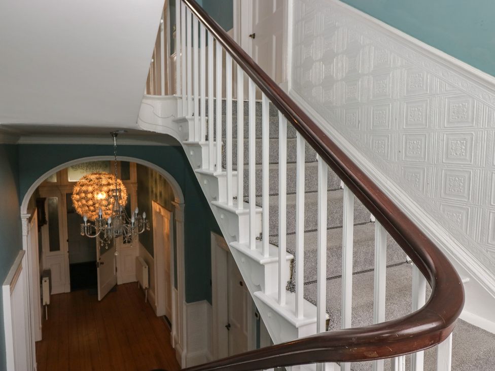 A staircase and chandelier in a hallway at 8 Corkickle Whitehaven