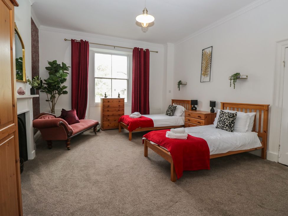 A bedroom with two beds and a sofa at 8 Corkickle Whitehaven