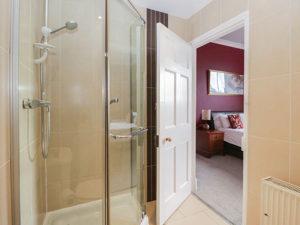 A bathroom with a shower and doorway to a bedroom at 8 Corkickle, Whitehaven