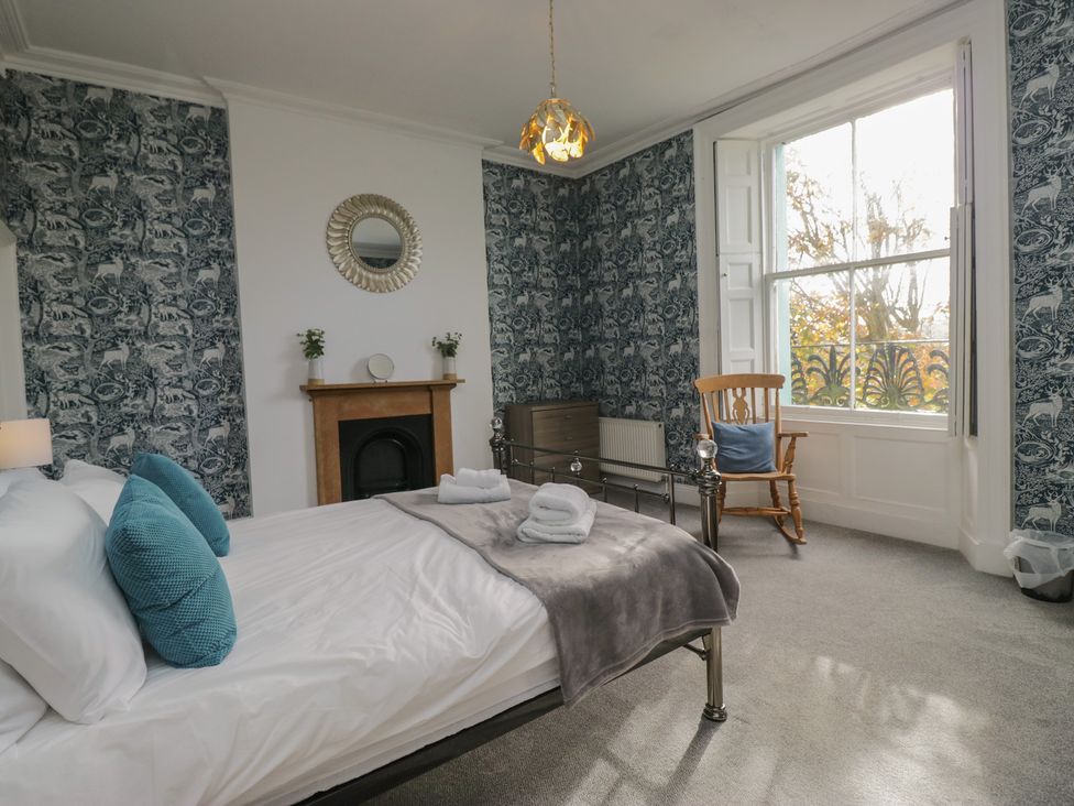 A bedroom with a bed and chair at 8 Corkickle Whitehaven