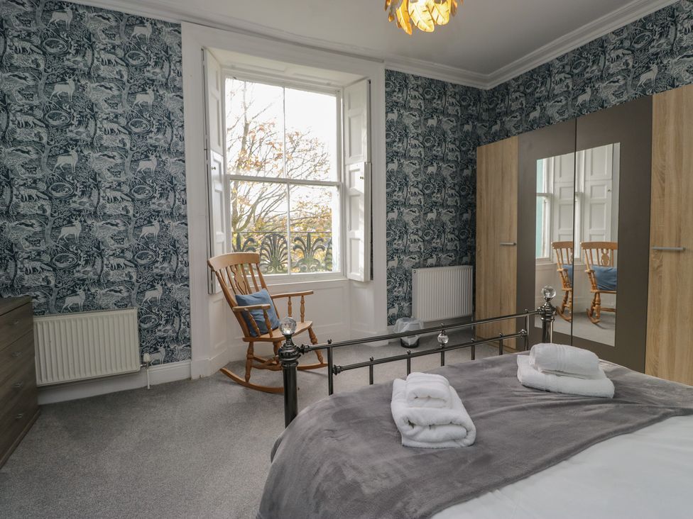 A bedroom with a bed and a rocking chair at 8 Corkickle Whitehaven