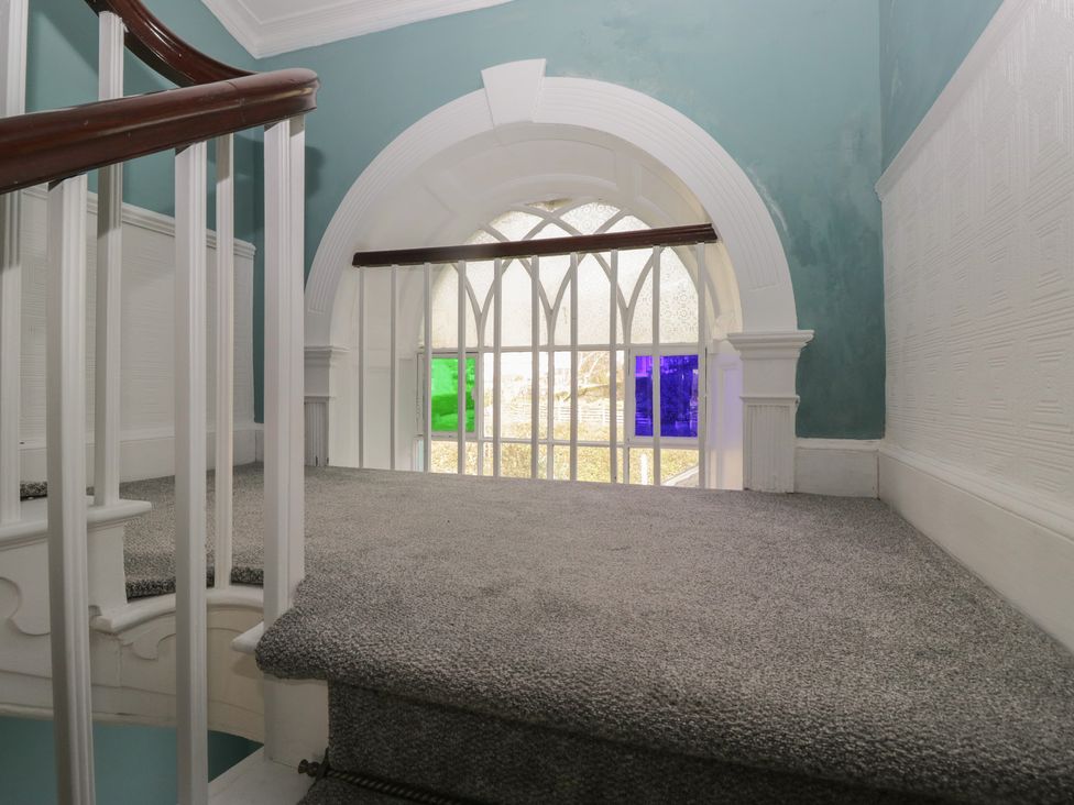 A landing with a staircase and large window at 8 Corkickle Whitehaven