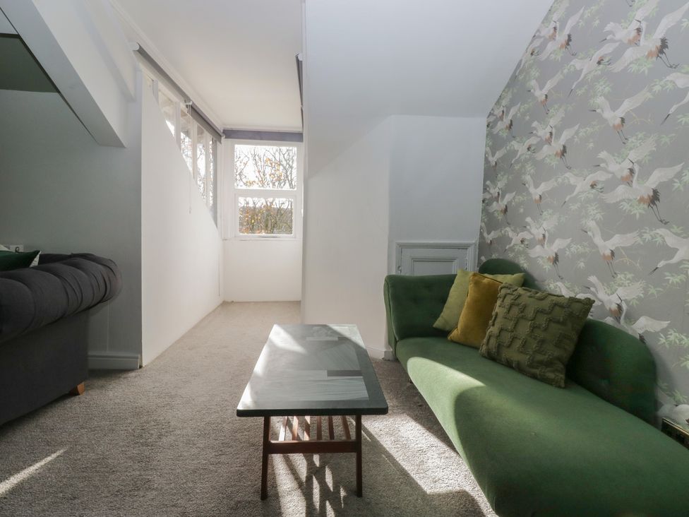 A living room with a green sofa and coffee table at 8 Corkickle, Whitehaven