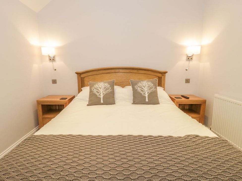 A bedroom with a bed and bedside tables at Riverside Cottage in Conwy