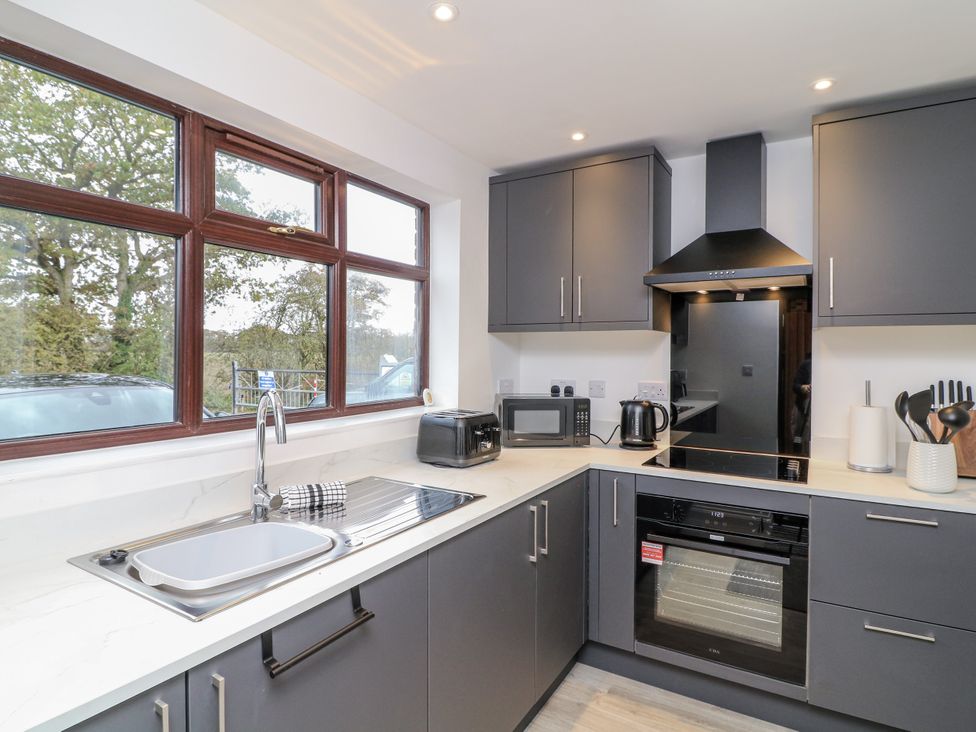 A kitchen with a sink, microwave, toaster, and oven at Station House in Scredington near Osbournby