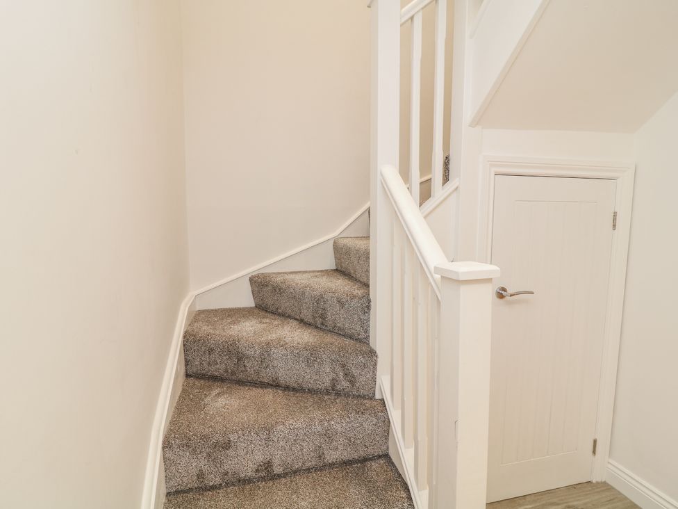 A staircase with carpet and a door at Station House in Scredington near Osbournby