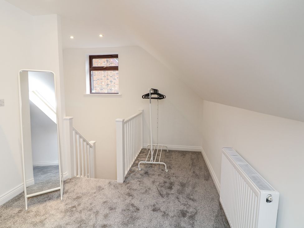 A landing area with a mirror and a hanging rack at Station House in Scredington near Osbournby