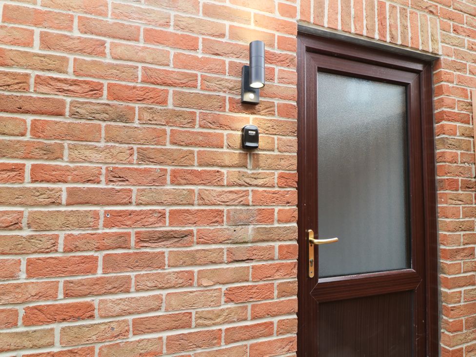 A door with light fixture on a brick wall at Station House Scredington near Osbournby