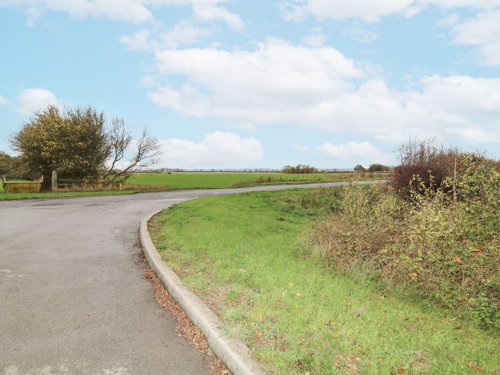 A road curving through grass and bushes at Station House Scredington near Osbournby