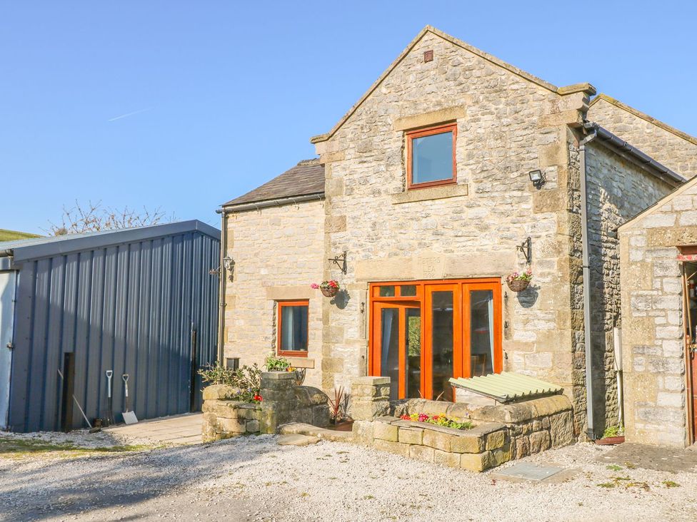 A stone house with large windows and a metal shed at Peters Lea Bakewell