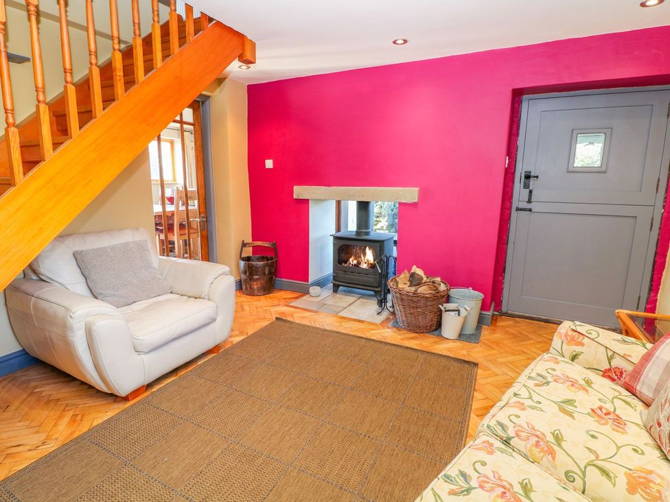 A living room with a fireplace and staircase at Peters Lea in Bakewell
