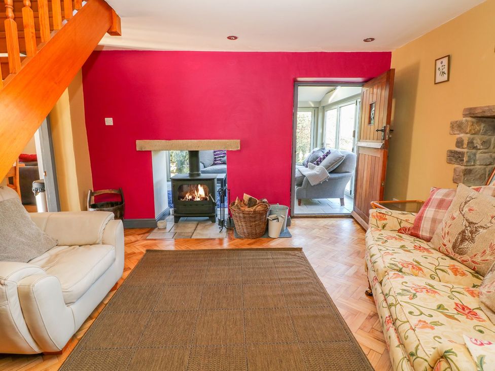 A living room with a fireplace and seating area at Peters Lea Bakewell