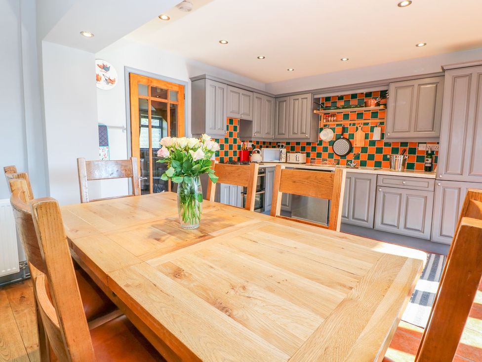 A kitchen with a wooden table and chairs at Peters Lea in Bakewell